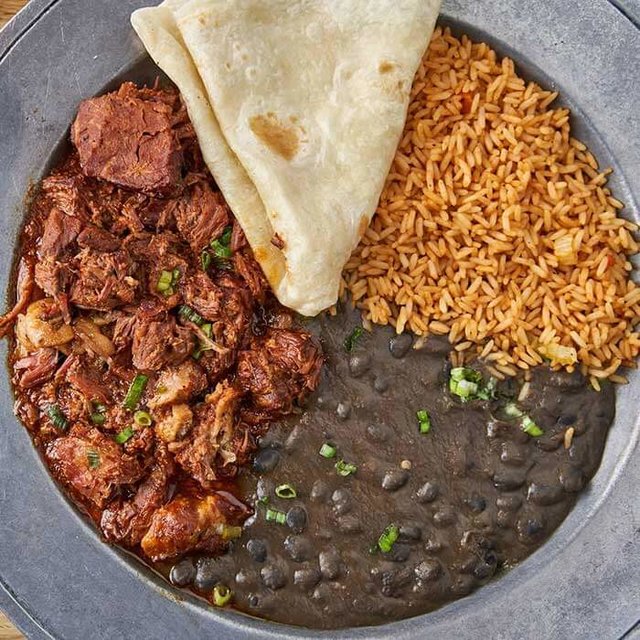 Delicious Tex-Mex platter featuring warm tortillas, flavorful rice, and succulent seasoned meat.