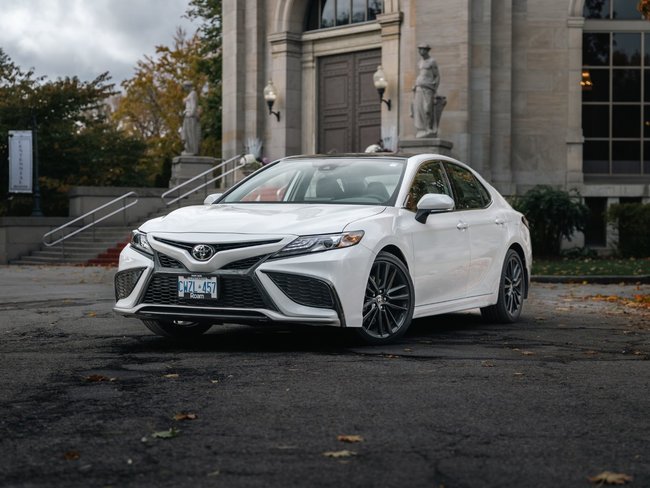 White Toyota sedan from Roam in front of building