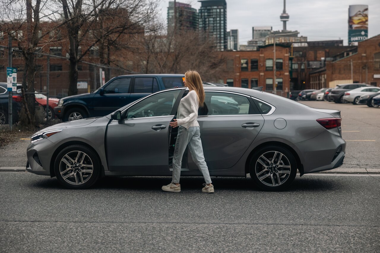woman getting into white Roam car