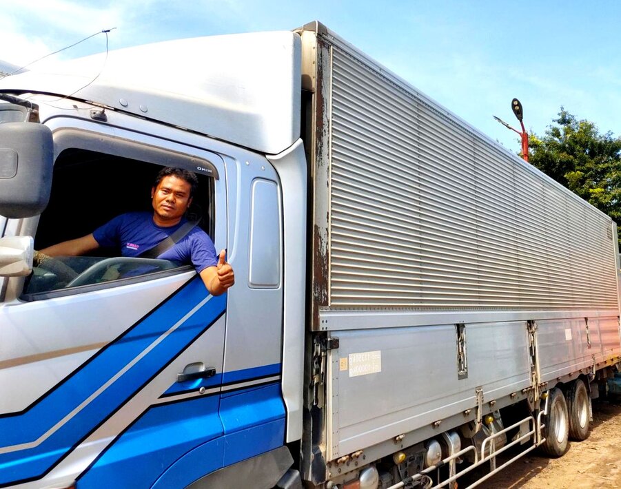 Karzo vendor truck driver giving a thumbs-up from the cab, symbolizing reliable trucking services