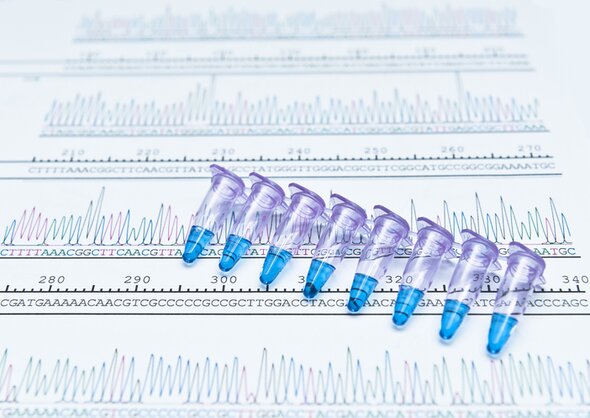 An image of a collection of small tubes on a background of sequencing data, representing next-generation sequencing enzymes for library preparation.