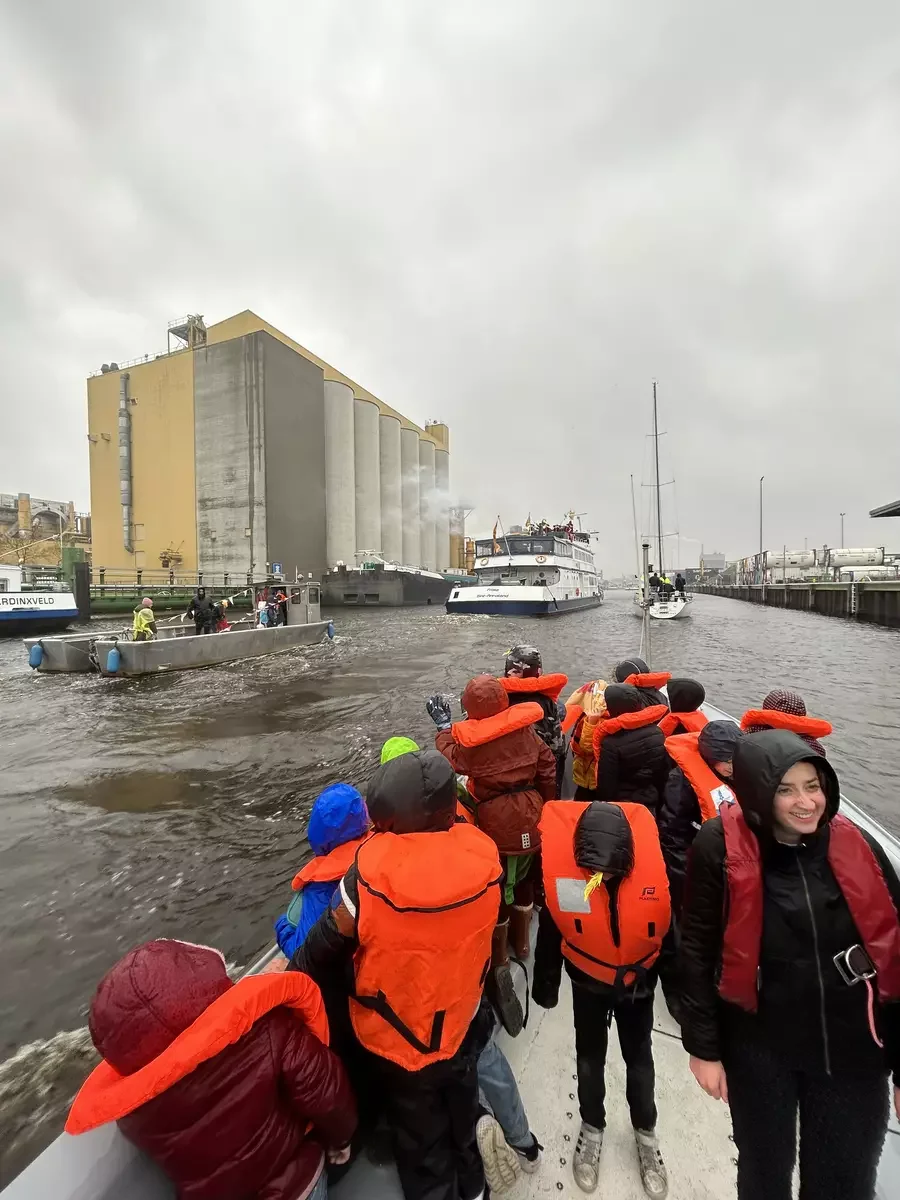 de dolfijnen zwaaien vanaf de whaleboat naar sinterklaas die in zijn pakjesboot de haven van Bergen op Zoom binnen vaart