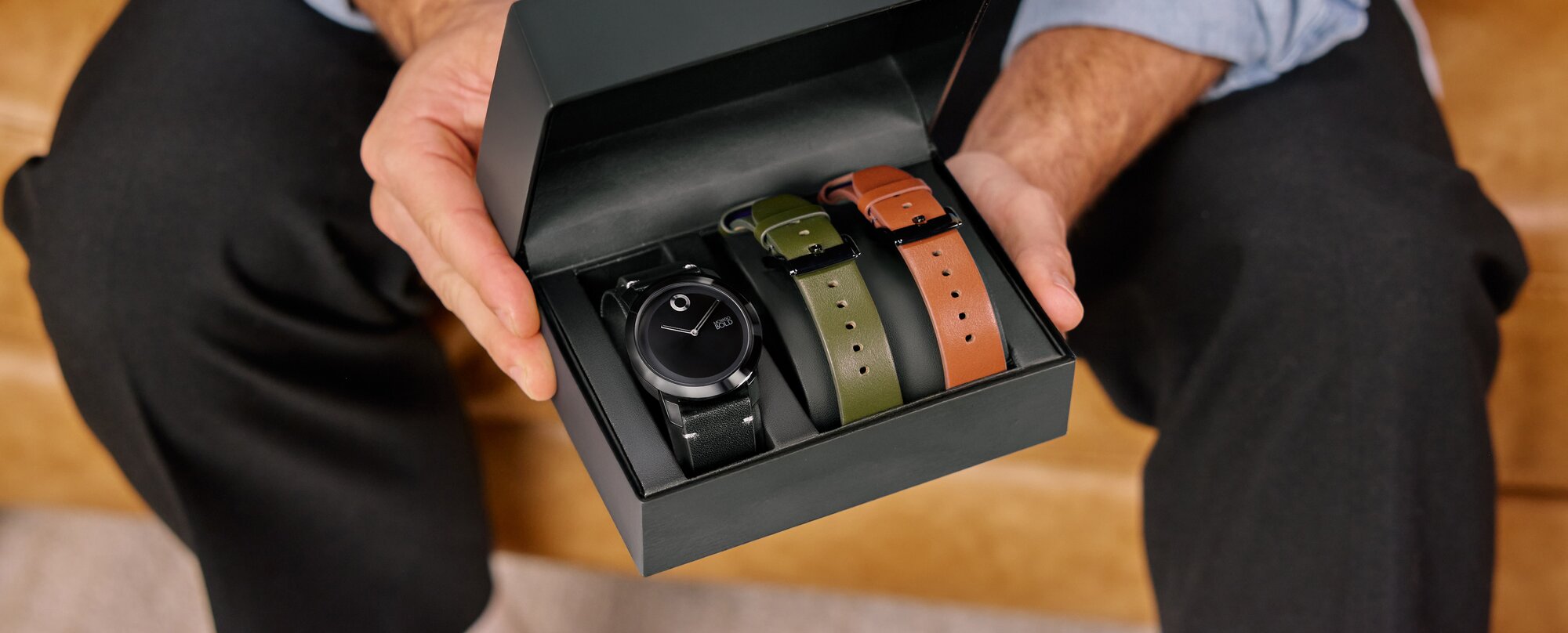 Model holding the movado trend impulse gift set in the box with interchangeable straps