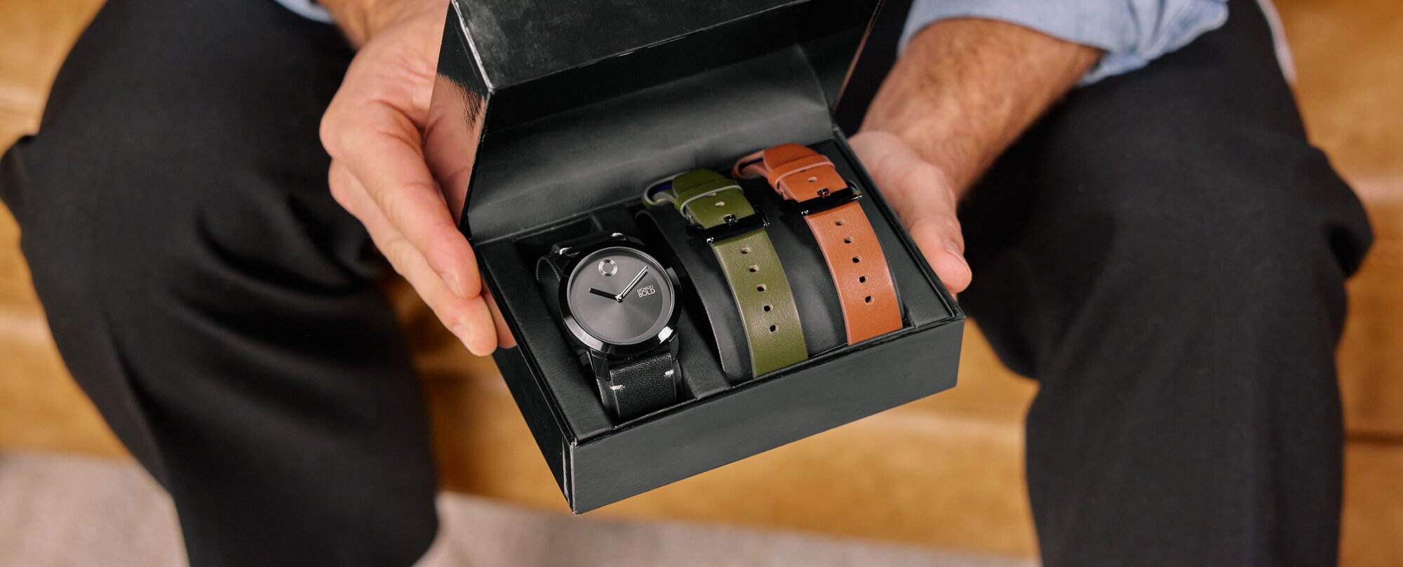 Model holding the movado trend impulse gift set in the box with interchangeable straps