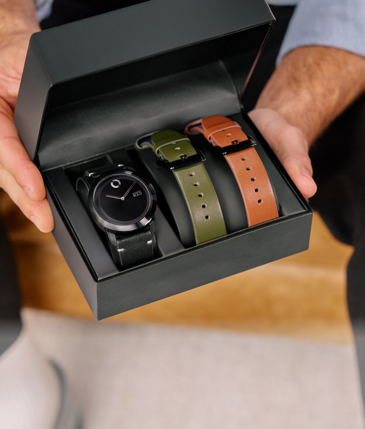 Model holding the movado trend impulse gift set in the box with interchangeable straps