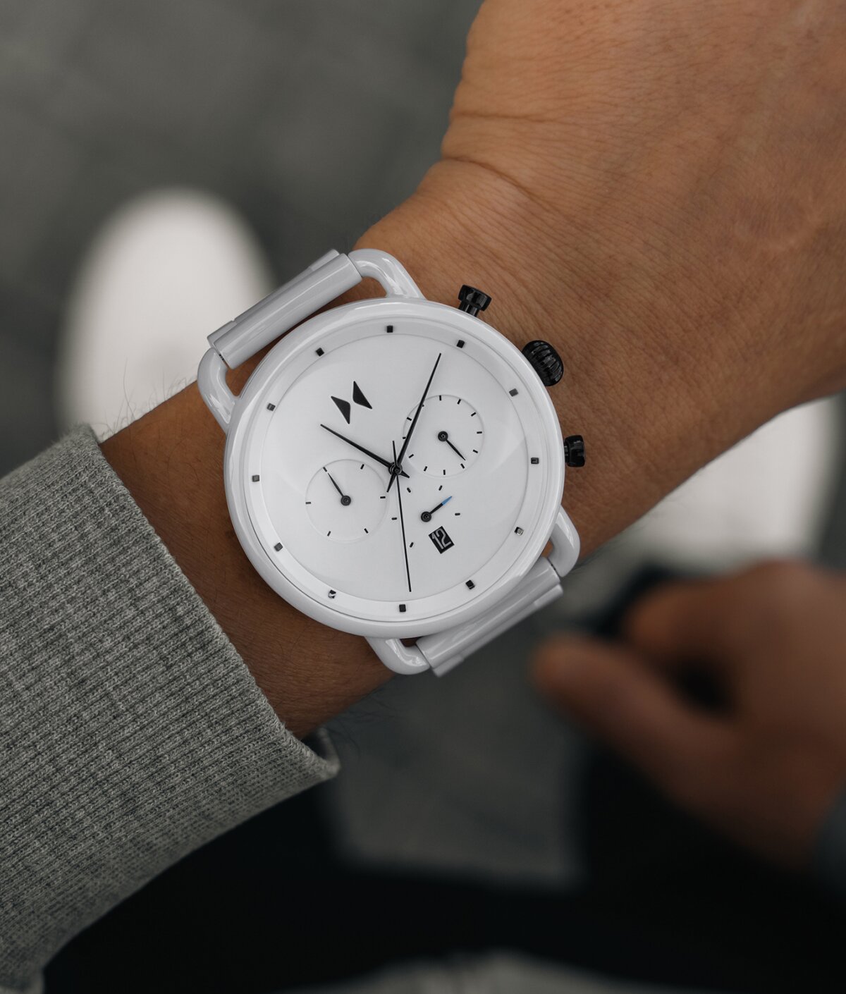 Model wearing men's MVMT Blacktop ceramic watch in white
