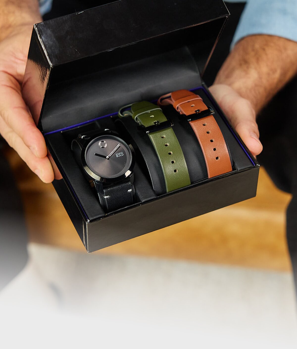 Model holding the movado trend impulse gift set in the box with interchangeable straps