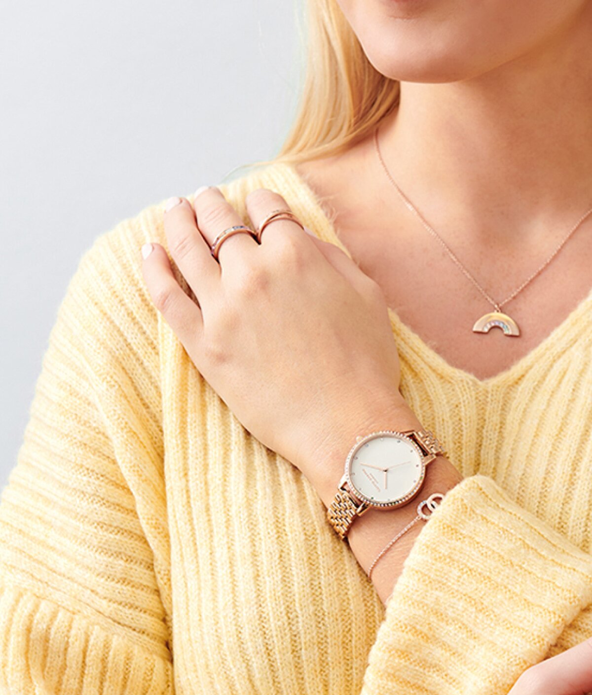 Olivia Burton Rainbow watch with rainbow marker crystals around the bezel on figure