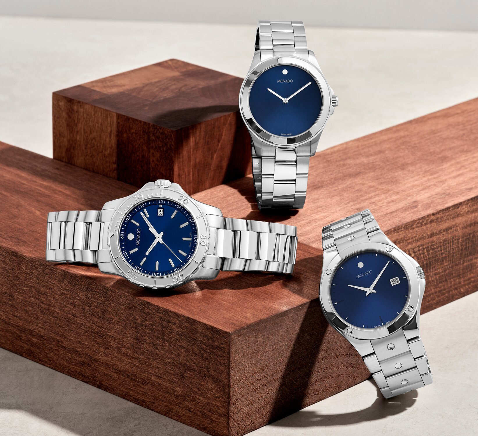 Movado Challenger, Movado Excel, and Movado Active sport watches with blue dials and silver bracelets
