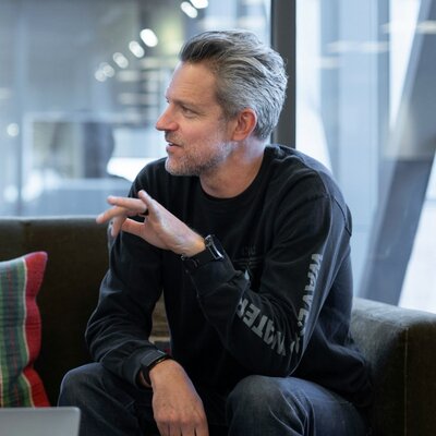 Man in conversation during a meeting, representing confidence, wellbeing and smarter health insurance Plan Pro+ with Level Health.