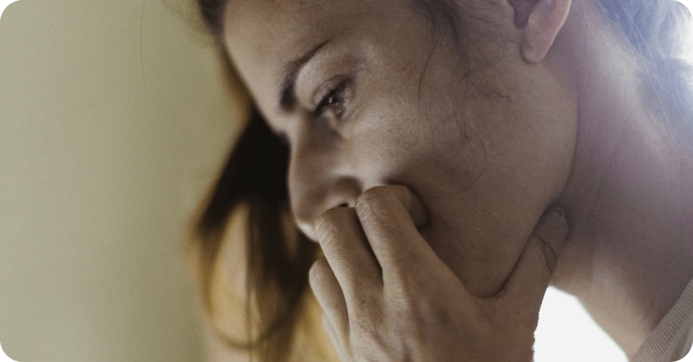 A parent rests her face in her hands as she researches online to find out more about her child's selective mutism condition