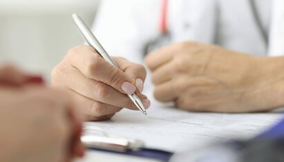 A person's hand as they take the MoCA vs. MMSE