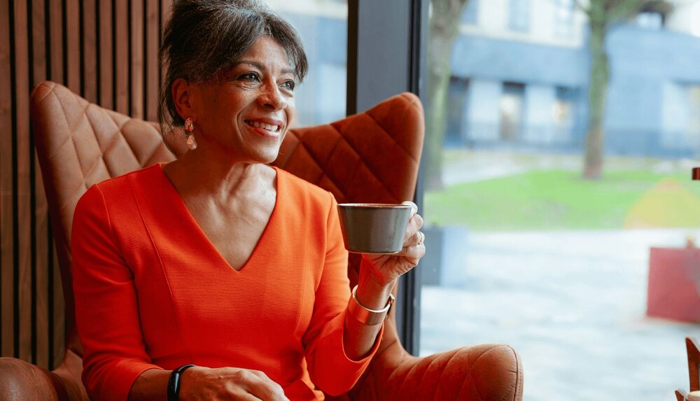 A woman sit in a chair about to speak and spasmodic dysphonia most often affects women in middle age