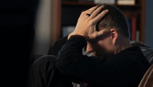 man sitting down holding his head and discussing anger discussion questions