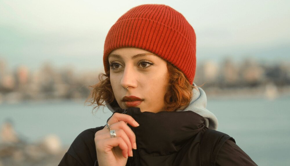 woman with a hat on looking outward and thinking