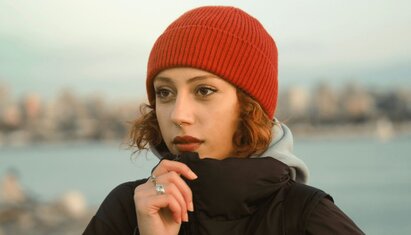 woman with a hat on looking outward and thinking