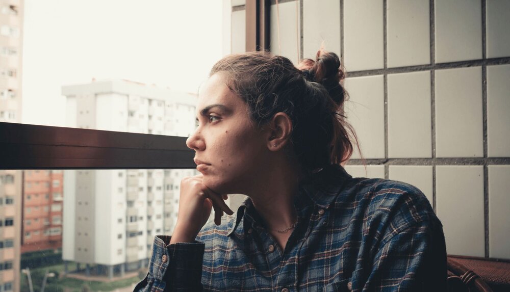 person looking out of a window and challenging anxious thoughts