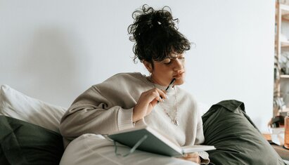 woman sitting down and thinking about what to write in her gratitude journal worksheet