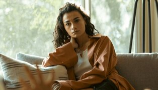 woman sitting and staring out into space using DBT mindfulness skills to regulate emotions
