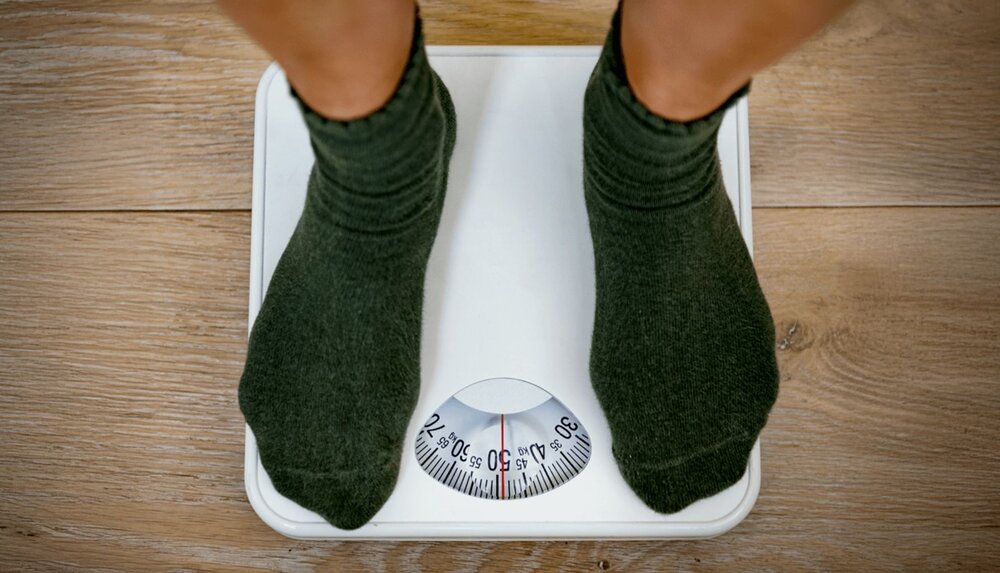 person on a scale after using cbt weight loss worksheets for healthy eating habits