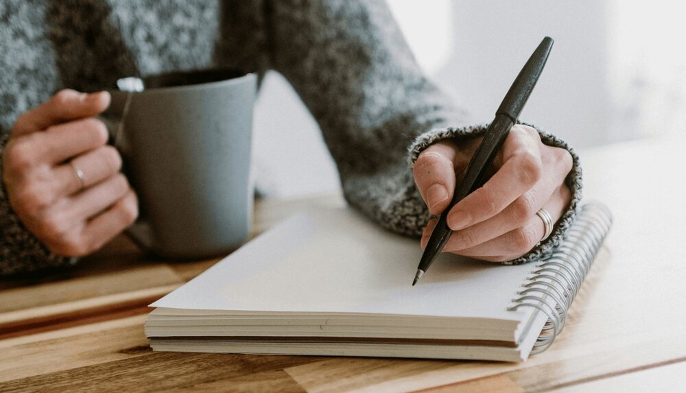 therapist writing notes about CBT psychoeducation in a notebook