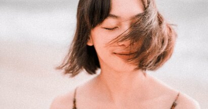 A woman with her eyes closed uses anxiety coping worksheets to deal with stress 