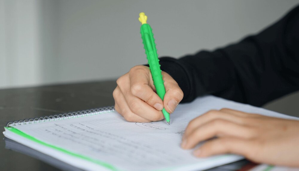 A patient holds a pen and takes the montreal cognitive assessment (MoCa)