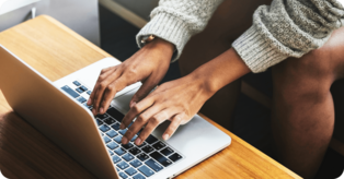 A therapist types up GIRP notes on a laptop, following the format of GIRP notes examples