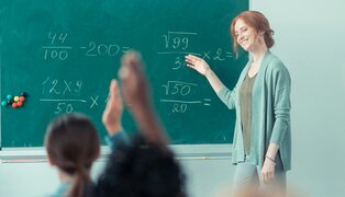 Female student raising her hand to talk with the teacher about her excuse absence letter