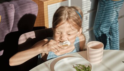 A young girl with sensory processing disorder does not enjoy the texture of her meal.