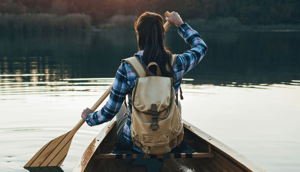 person in a canoe on water practicing self-discovery worksheets activities