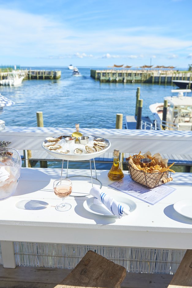 Oysters and french fries set on the rail at Duryea's Orient Point with a view of the sea