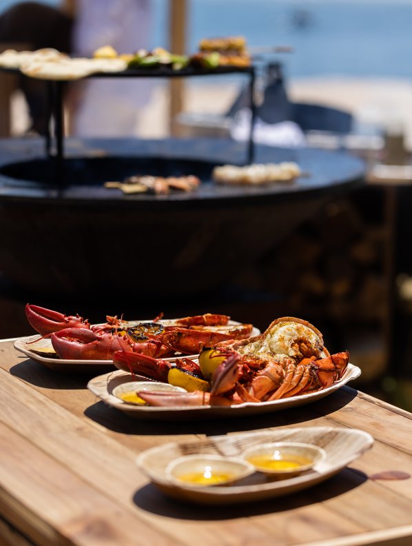 Assortment of asado brochettes with photo of outdoor grill at Duryea's Montauk