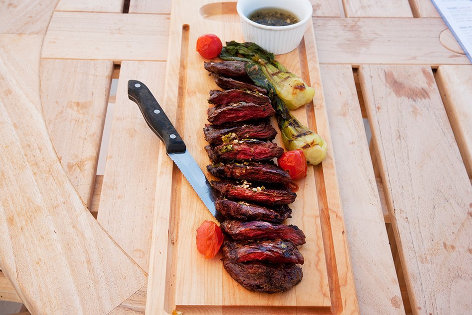The Sliced Skirt Steak on wooden board with Chimichurri Sauce