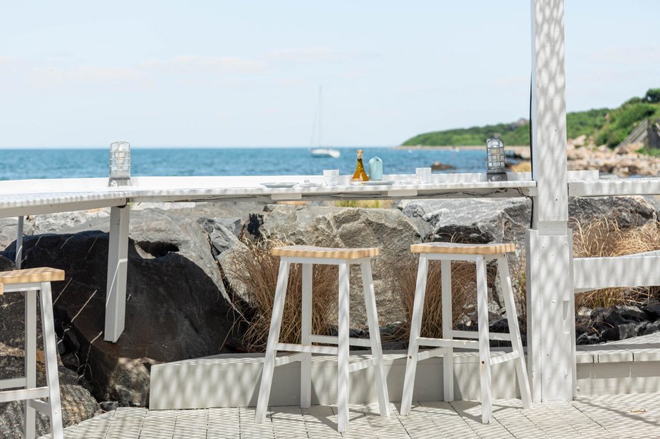 Stools alongside the seating rail with view of the sea