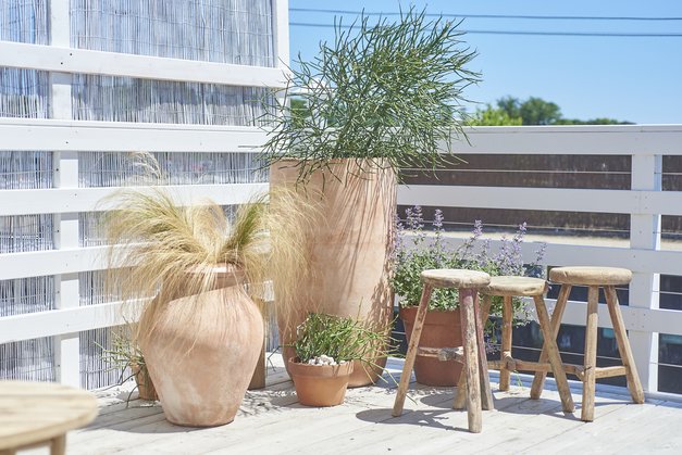 Assortment of urns with plants and stools in corner of the deck at Duryea's Orient Point 