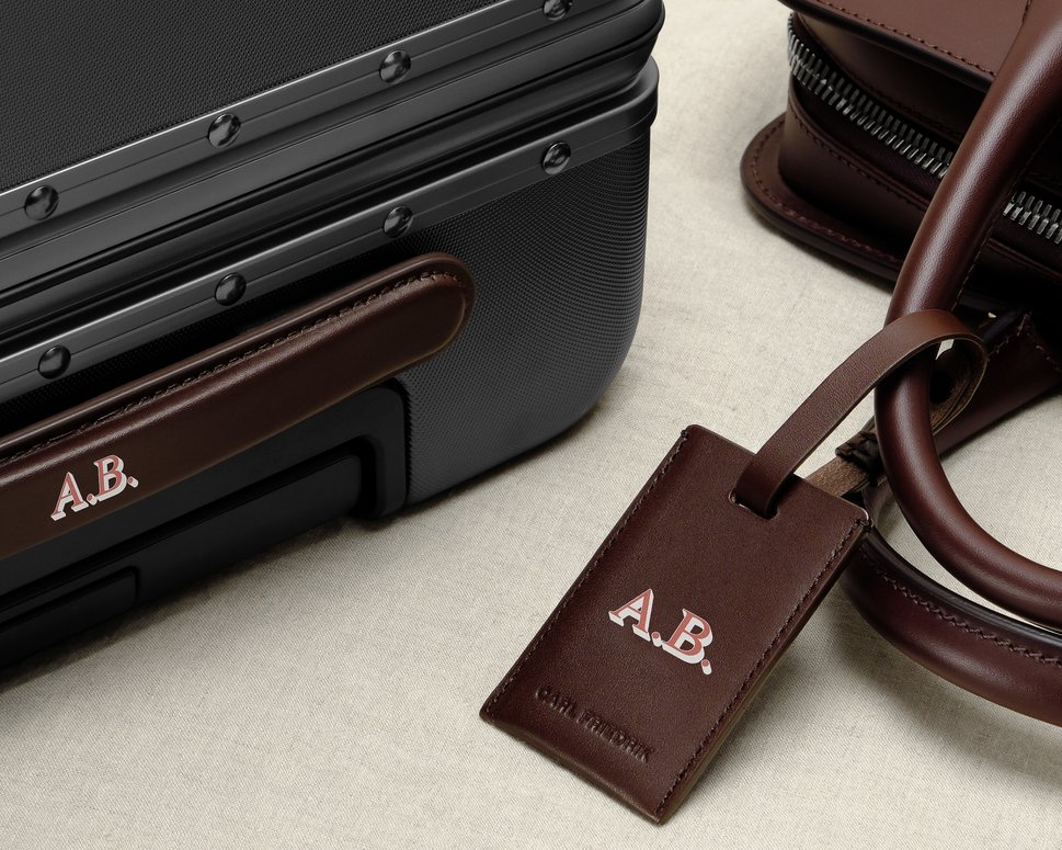 Customised leather suitcase beside customised brown leather luggage tag