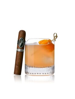 Cocktailglas mit Eis und Orangengarnitur neben einer Davidoff Escurio-Zigarre auf weißem Hintergrund.