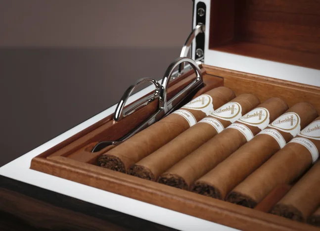 Opened Davidoff Air de Famille Series II Ziricote Humidor with Davidoff cigars and a scissors cutter.