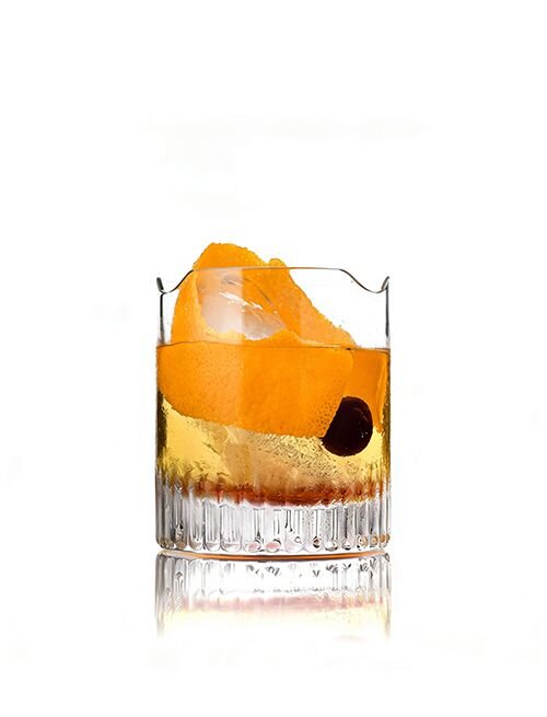 Whiskeyglas mit Orangenschale und Kirsche auf weißem Hintergrund.