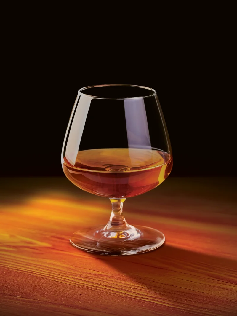 A Davidoff Nicaragua cigar standing next to a glass with whisky.