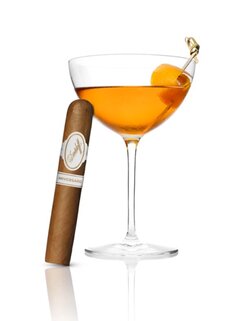 Cocktail mit Twist neben einer Davidoff Aniversario-Zigarre, strahlt Genuss und Raffinesse aus.