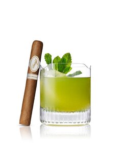 Grüner Agave Cocktail mit Minzgarnitur neben einer Davidoff „Aniversario“-Zigarre.