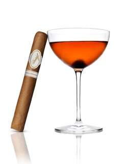 Davidoff Aniversario-Zigarre neben einem bernsteinfarbenen Cocktail, strahlt Genuss und Eleganz aus.