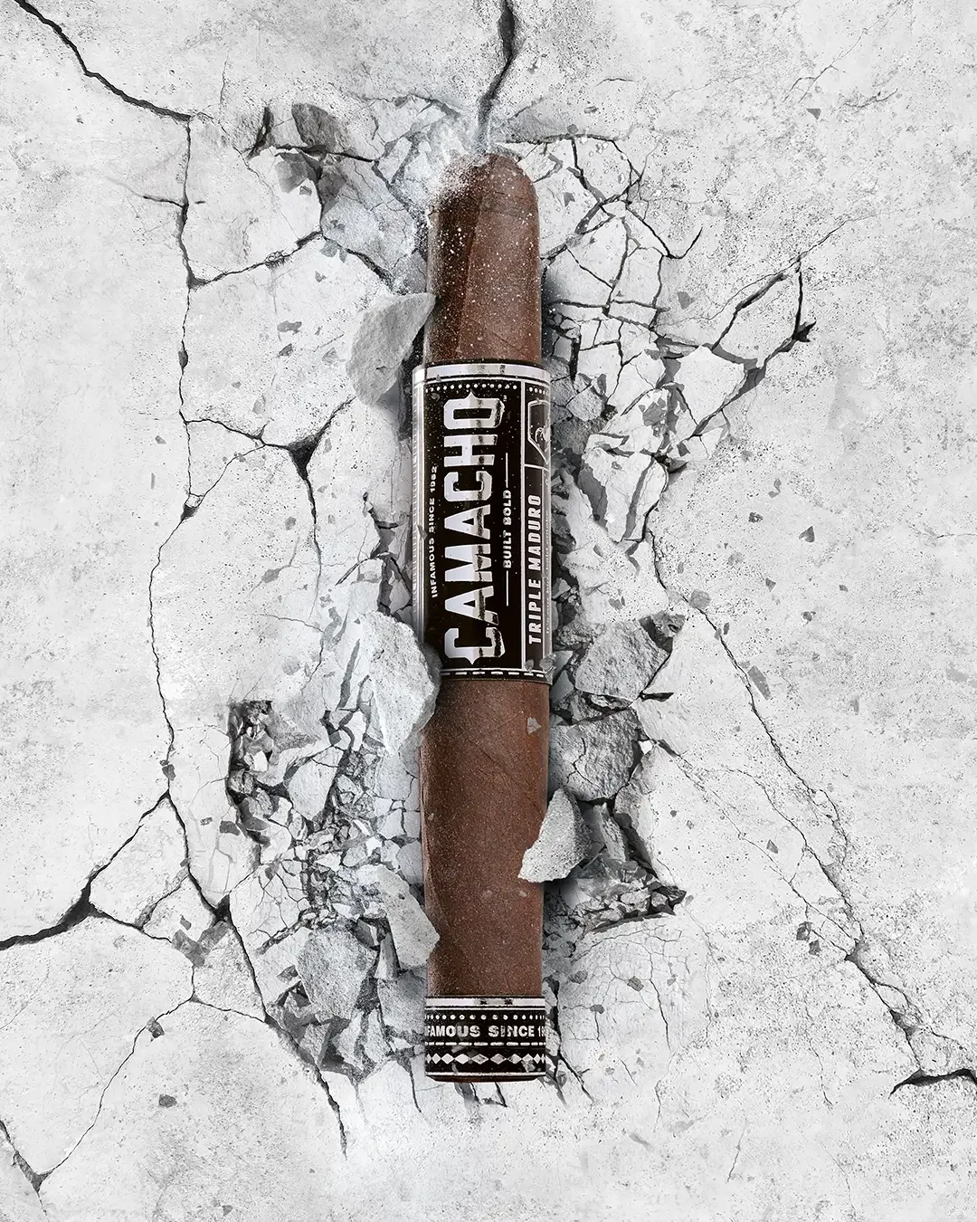 Camacho Triple Maduro Zigarre auf rissigem Beton mit dunklem Maduro-Deckblatt und markanter Banderole.