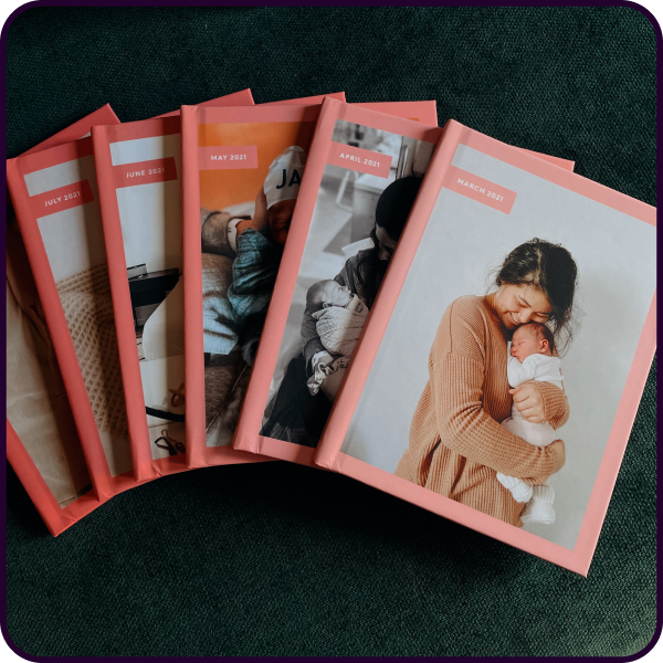 Fanned out display of custom baby photo books showing baby milestones