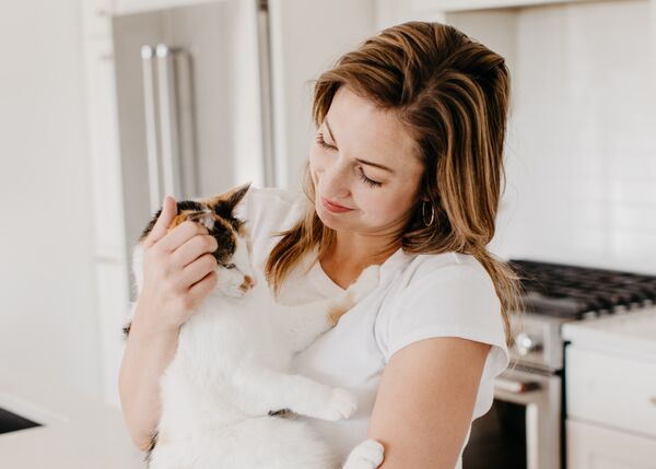 Woman Snuggling with Cat After Treatment