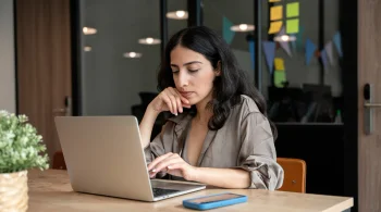 Woman focused on a laptop in a modern office