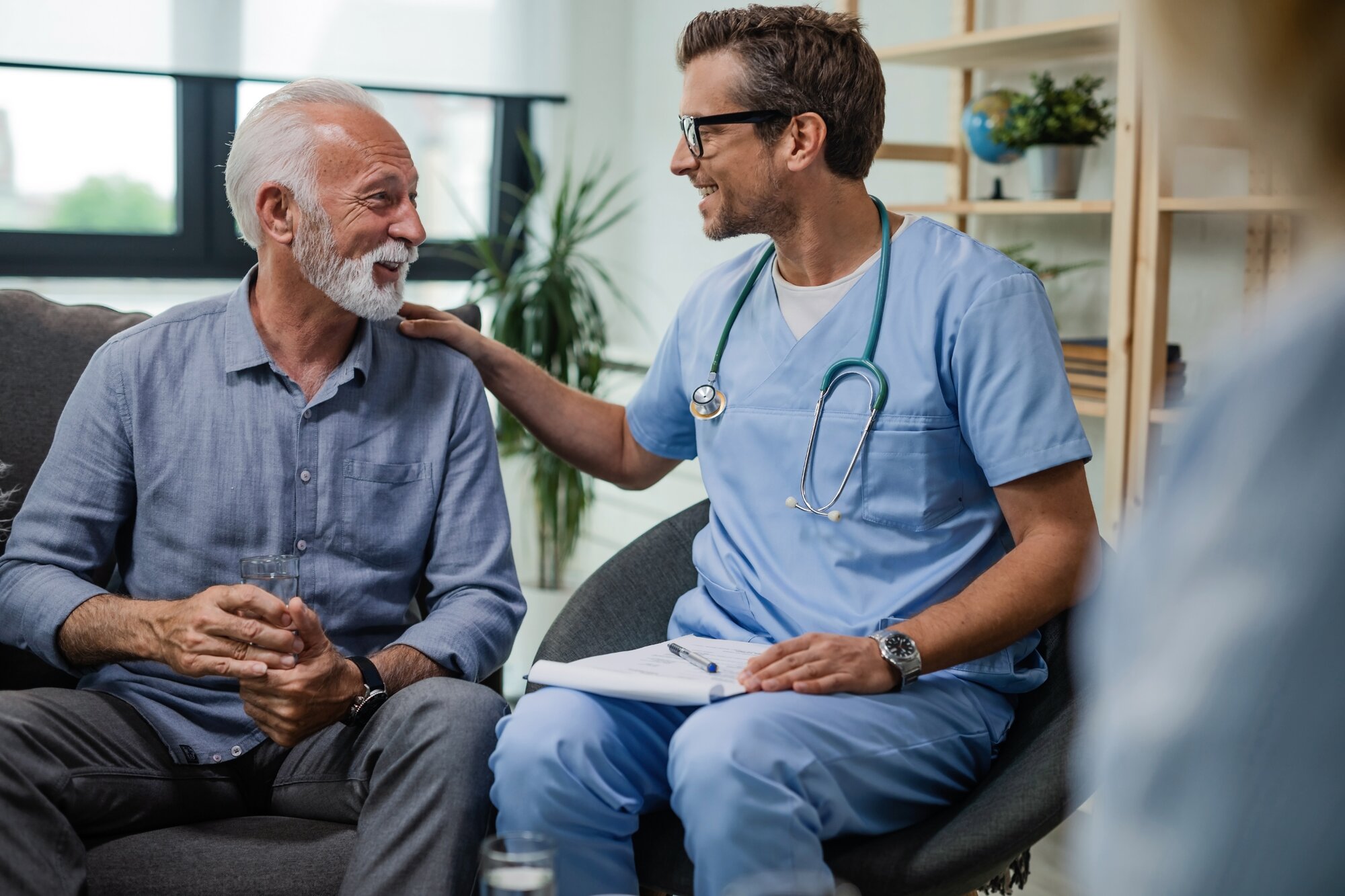 An image shows a male nurse and a patient having a conversation about the need for a living will.