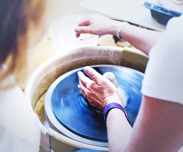 Two people are working with clay to create pottery